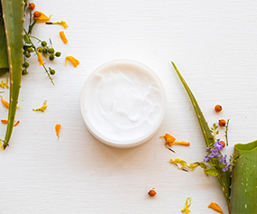 Skin brightening cream with natural ingredients like leaves and flowers for radiant complexion